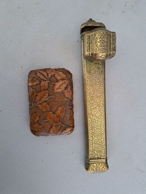 a small piece of wood next to a lighter on a table