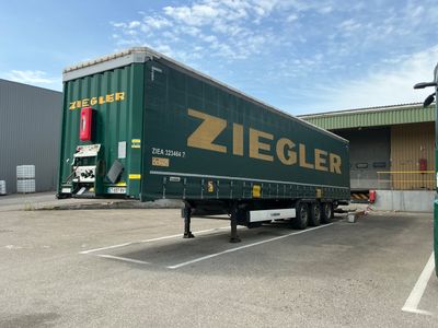 un camion garé sur un parking, avec un bâtiment en arrière-plan