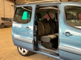 a small blue van with its doors open in a garage