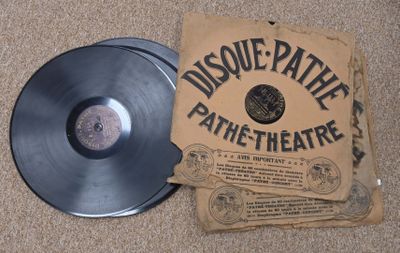 un disque vinyle noir posé par terre à côté d'un colis