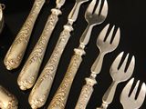 a lot of silver forks and spoons on the table