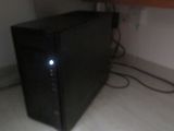 a black microwave sitting on the floor next to a cabinet