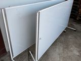 two white boards sitting on top of each other in a room