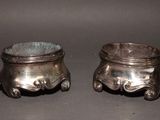two silver pots sitting next to each other on a table
