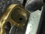 a close up of a metal object with a gold skull on it