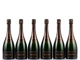 six bottles of champagne lined up in a row