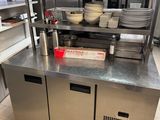 stainless steel counter top in a commercial kitchen with dishes stacked on it