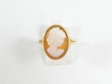 gros plan d'une bague en or avec un camée représentant une femme