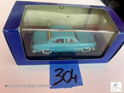 La petite voiture bleue se trouve dans la boîte posée sur la table.