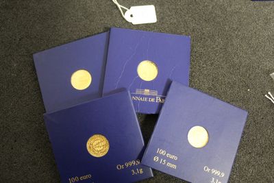 trois cartes bleues ornées de pièces d'or, posées sur une table