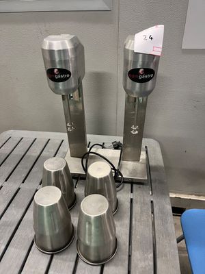 quatre tasses posées sur une table à côté d'un distributeur de tasses
