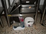 several pans and pans are stacked on a stainless steel table