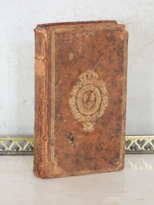 un vieux livre posé sur une table à côté d'un miroir