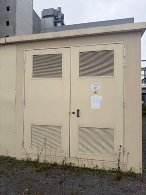deux portes situées sur le côté d'un bâtiment sur lequel est accrochée une enseigne