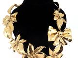 une image représentant un collier en or orné de fleurs et de feuilles