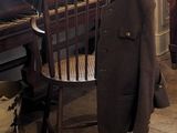 un manteau accroché au dossier d'une chaise devant un piano