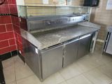 stainless steel counter top in a commercial kitchen with a red tiled wall