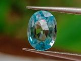 un gros plan d'un diamant bleu tenu par une pince