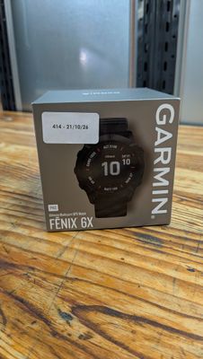 a close up of a box on a wooden table with a watch on it