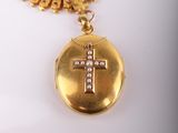 a gold locke with a cross on it on a necklace