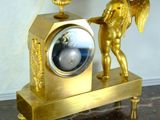 a gold clock with an angel figurine on top of it