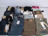 plusieurs paires de jeans sont disposées sur une table