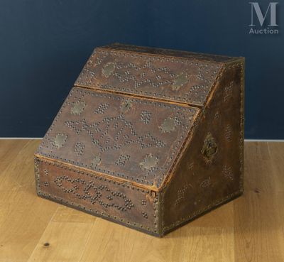 une vieille boîte en bois posée sur un parquet, près d'un mur bleu