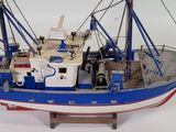 a model of a fishing boat on display on a white surface