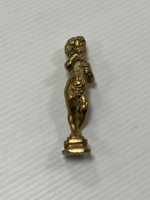 un gros plan d'une statue en or posée sur une surface blanche