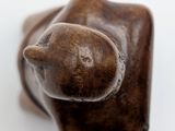 a brown cat statue sitting on top of a white surface