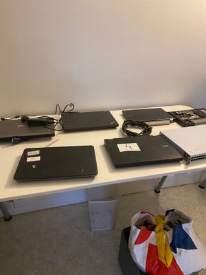 Plusieurs ordinateurs portables sont posés sur une table dans une pièce