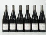 six bouteilles de vin sont alignées sur une table