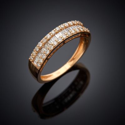 a gold ring with baguets and diamonds on a black background