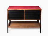 une photo d'une commode noire et rouge posée sur une étagère en bois