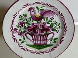 a decorative plate with a bird and flowers on it