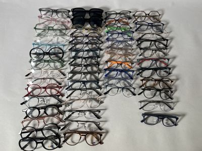 de nombreuses paires de lunettes disposées sur une surface blanche