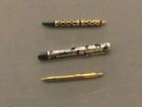 three pens that are sitting next to each other on a table