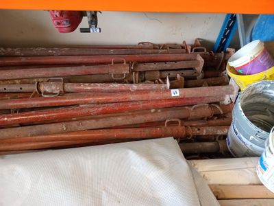 un tas de tuyaux posé par terre près d'un mur