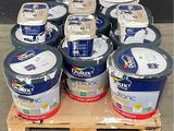plusieurs seaux de peinture posés sur une palette devant un mur