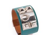 un gros plan sur un bracelet en cuir vert muni d'un fermoir en métal