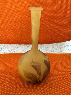 a vase that is sitting on a chair with a orange background