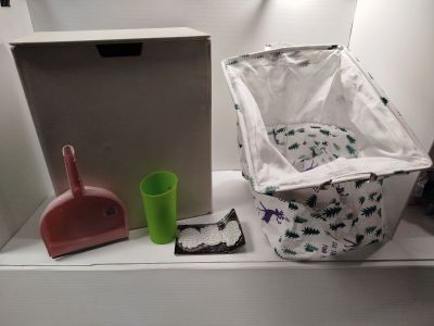 une étagère blanche sur laquelle se trouvent une poubelle, une poubelle et encore une poubelle