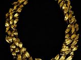 a gold necklace on a black background