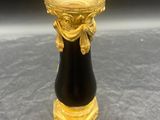 un vase noir et doré orné d'un motif doré