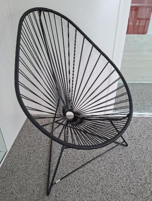 une chaise noire qui se trouve dans une pièce
