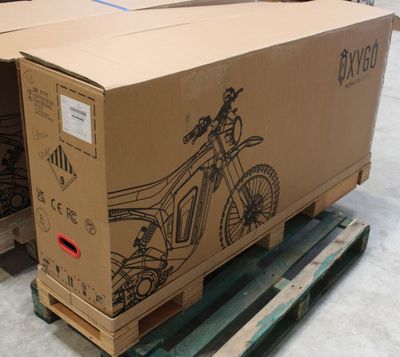 une caisse posée sur une palette, sur laquelle figure l'image d'une moto