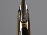 a close up of the tip of a fountain pen with a gold nib