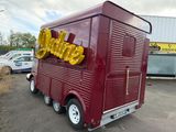 a red food truck that is parked in a parking lot