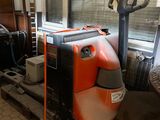 a large orange and black machine sitting on a pallet