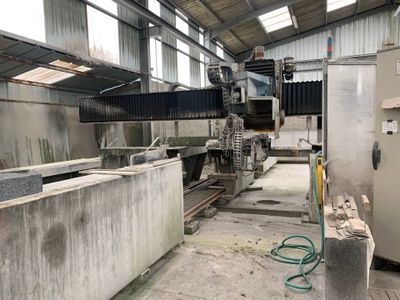 une grosse machine qui travaille sur un bloc de béton